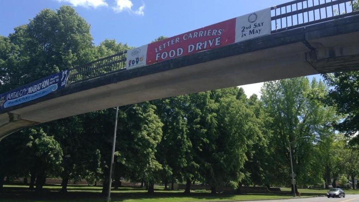 A banner over Capitol Way advertises the Letter Carriers’ food drive, which is set for 9 a.m. Saturday.