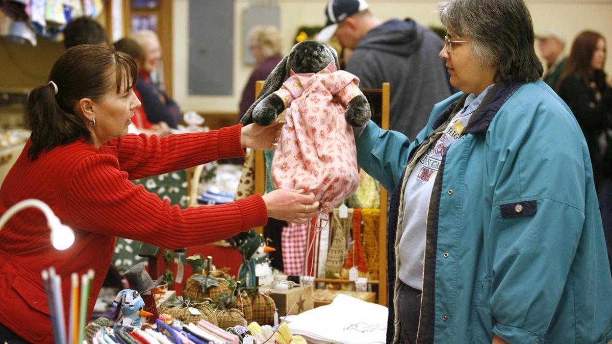 Toni Marsh (left) of Olympia looks at the handmade plush rabbit and pajama outfit that Gina Deaton of Roy put together for her newborn granddaughter during the 2011 Holiday Bazaar arts and crafts sale at the Thurston County Fairgrounds.