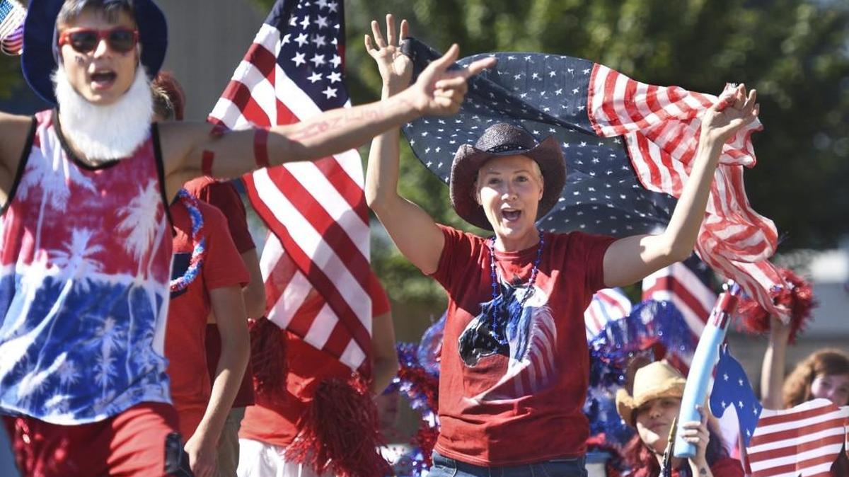 Devon Hlll (left) of Shreveport, Louisiana, and Kristy Dees of Tumwater dance on the Healing Hearts Ranch float in the 2015 Tumwater Fourth of July Parade on Capitol Boulevard.