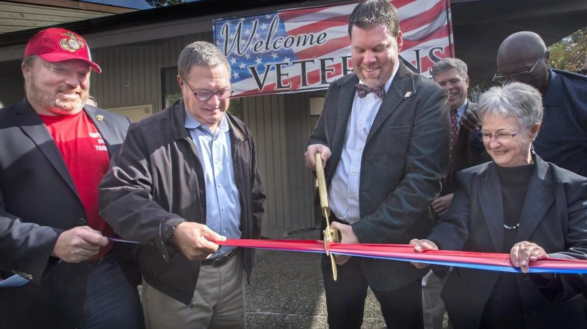 U.S. Congressman Denny Heck, center left, helps Lacey Mayor Andy Ryder cut the ribbon for the Lacey Veterans Services Hub grand opening in Lacey on Friday.