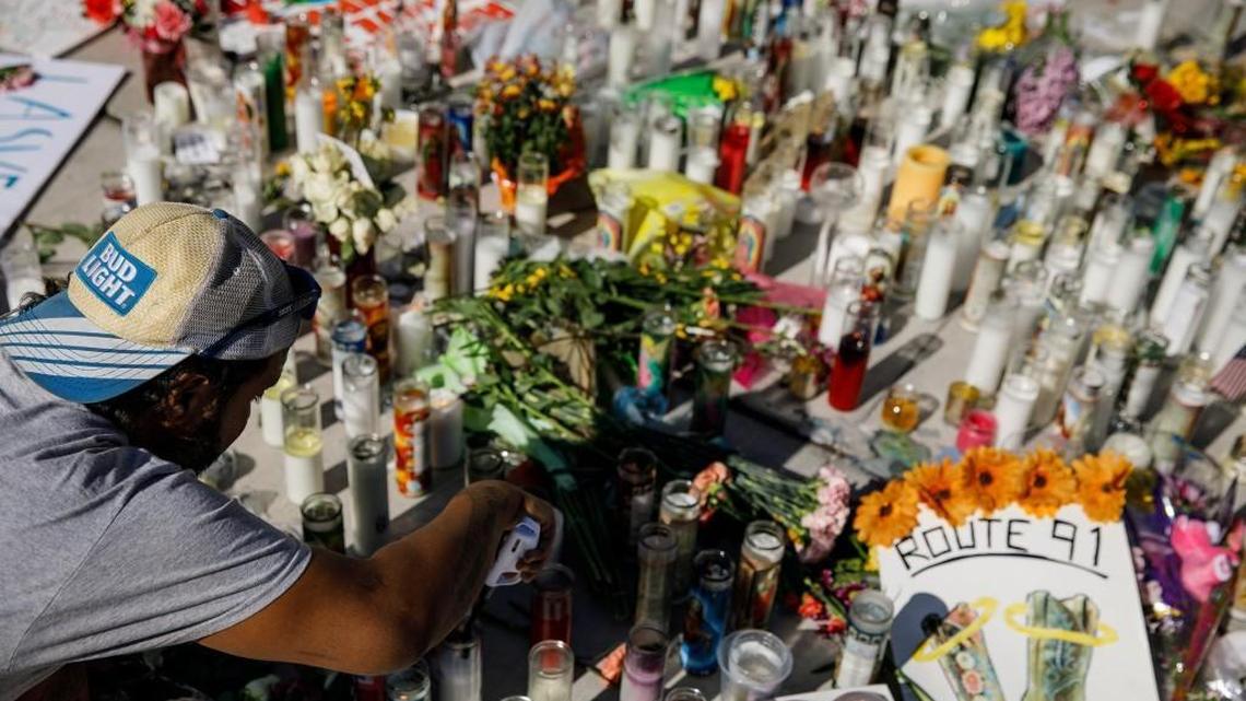 Matthew Edwards lights candles at a makeshift memorial for the victims of Sunday’s mass shooting at the intersection of Sahara Ave. and Las Vegas Blvd. in Las Vegas on Tuesday.