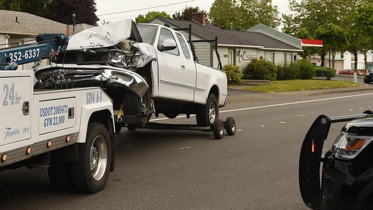 A pick-up truck is towed away after four people were injured in a crash Wednesday morning at the busy intersection at Ruddell Road and Lacey Boulevard.