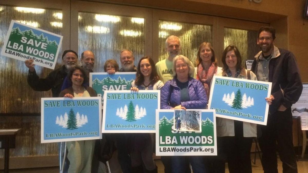 Outside council chambers Tuesday night at City Hall, members of the LBA Woods Park Coalition celebrate the purchase of a 74-acre parcel in southeast Olympia.