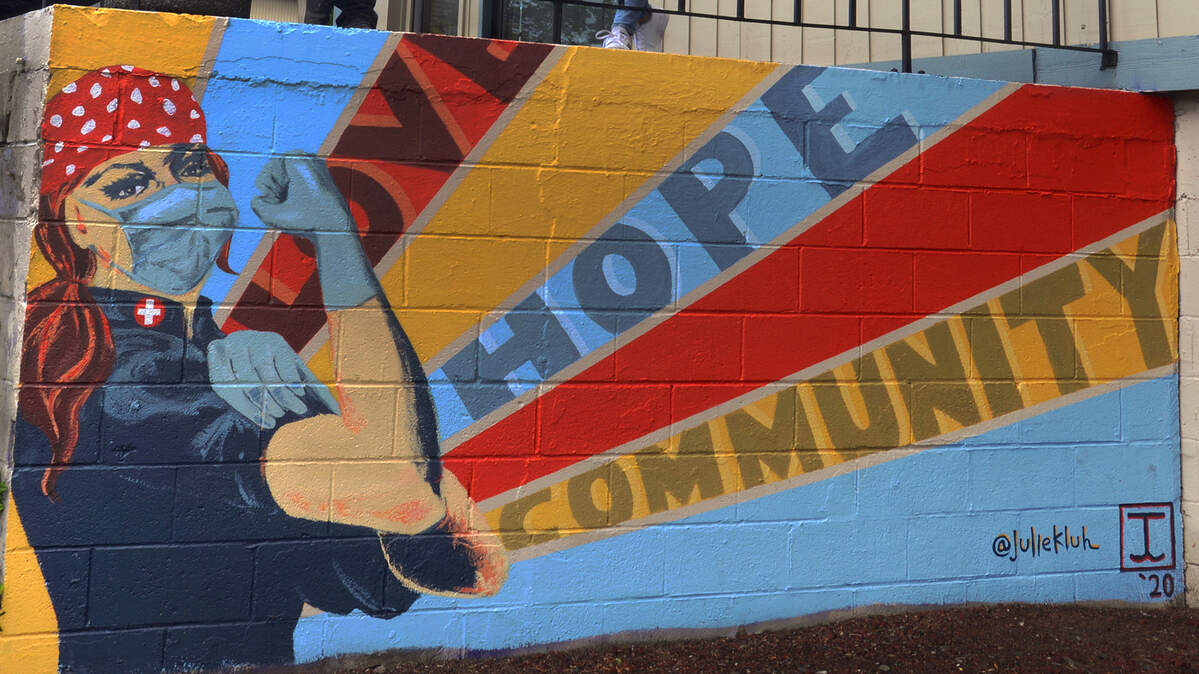 Artists Taylor Clinton and Julie Kluh stand above their vision of the Rosie the Riveter, a Northwest iconic symbol created with a message of hope during the COVID-19 crisis.