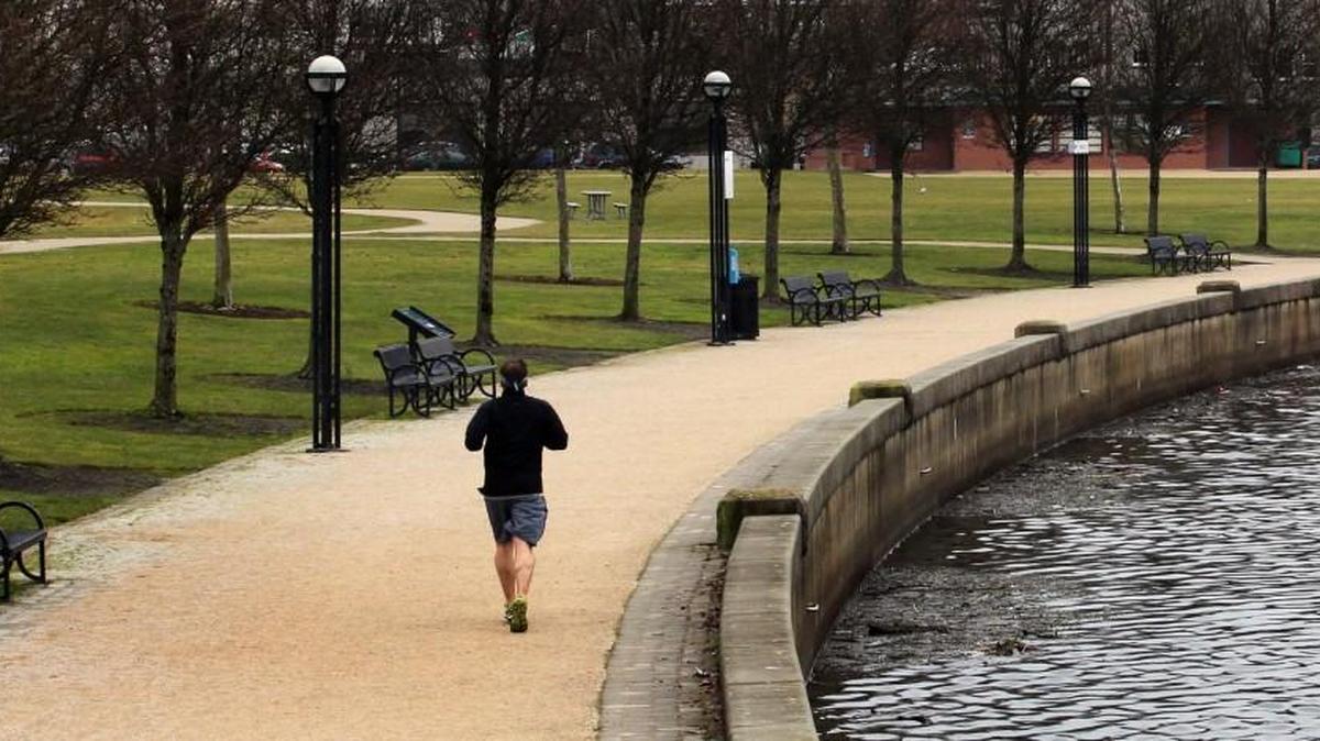 A lone runner enjoys the mild temperatures along the Heritage Park path around Olympia's Capitol Lake.