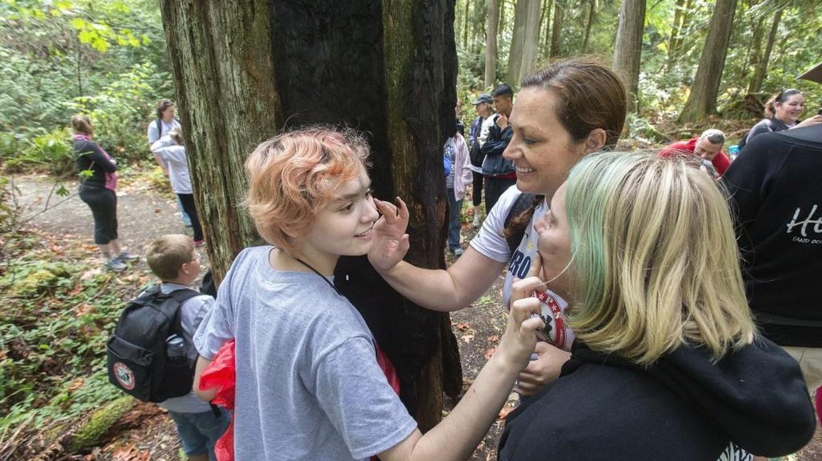 
Kara Levy, 13, left, Brittany Tipps, 15, and TAPS group leader Renee Monczynski, center, mark each other’s faces with ash, a camp tradition for finishing a challenge course at IslandWood Camp on Bainbridge Island. Tragedy Assistance Program for Survivors hosted a recent weekend camp for families of fallen soldiers, who came from around the Northwest and throughout the nation. The goal is to offer kids and parents restorative activities in nature. Volunteer active duty soldiers or recent veterans help mentor kids.
