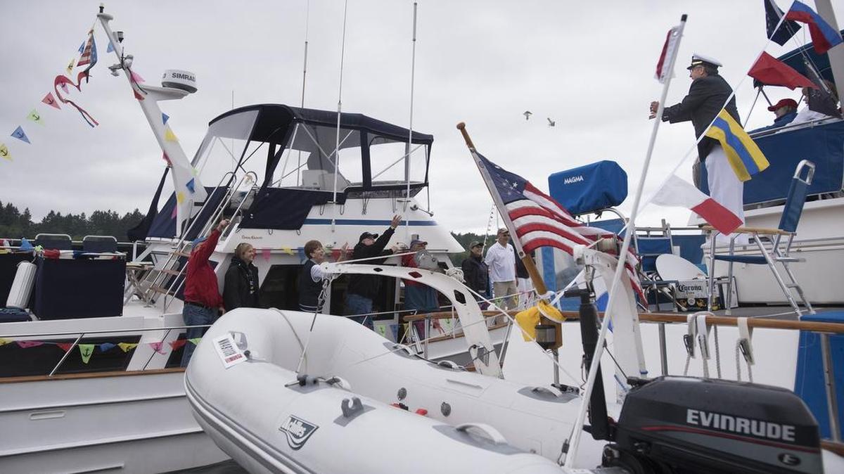The crew of "True North" tosses bribes to head judge Commodore Mike Phillips during the Olympia Yacht Club's 2016 Decorated Boat Parade in Budd Inlet to commemorate the unofficial "opening of boating season" in the South Sound.