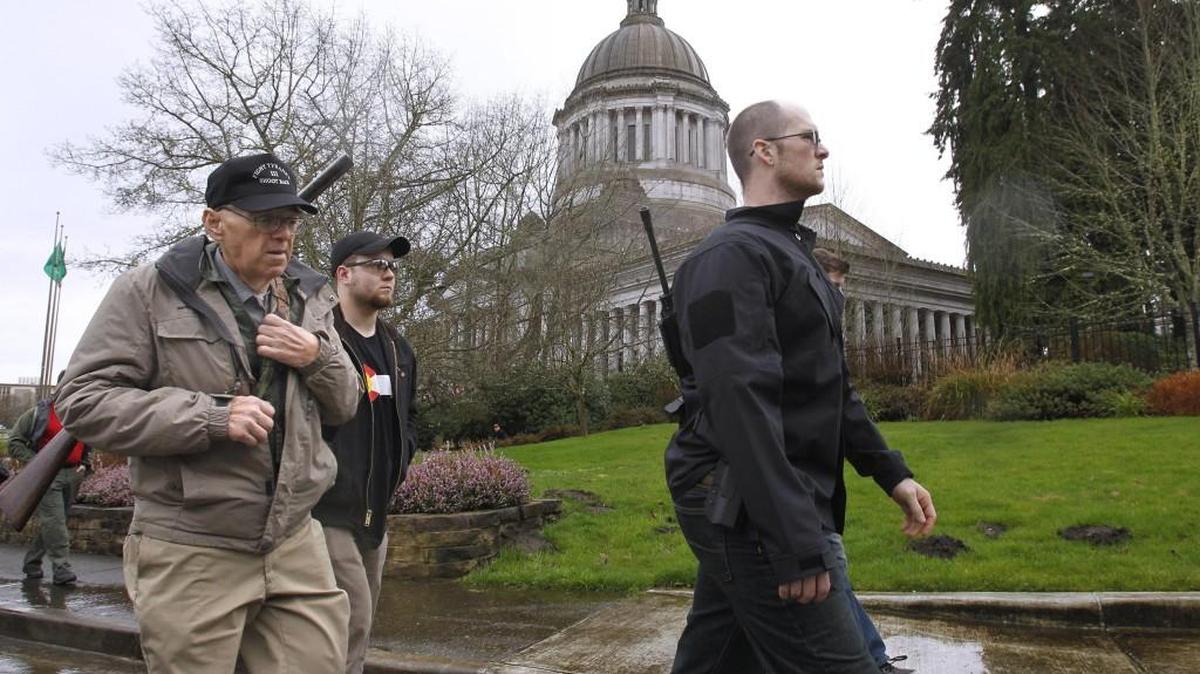 Second amendment defenders carry guns as they walk to the Governor's Mansion during the open carry demonstration on the Capitol Campus in Olympia on Saturday, Feb. 7, 2015.