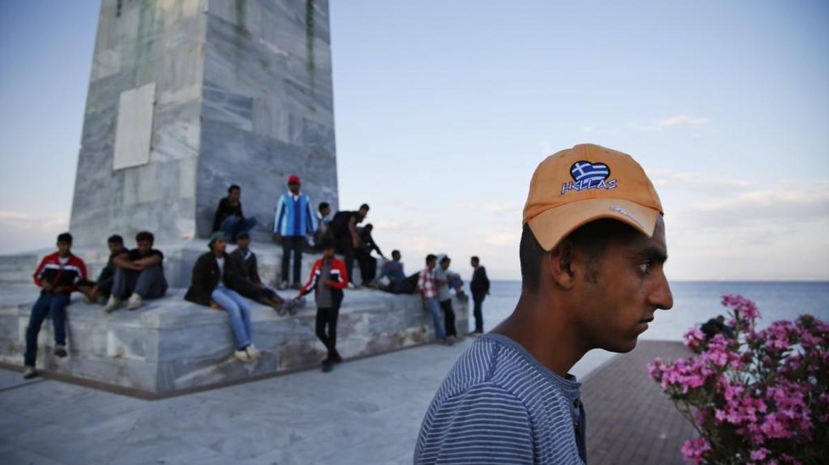 Migrants watch a departing ship in Mytilini port on the Greek island of Lesbos, Friday, May 27, 2016. The island, which has faced the brunt of Europe's migration crisis is hosting thousands of refugees and migrants, stranded in Greece after the northern Greek border was closed. (AP Photo/Lefteris Pitarakis)