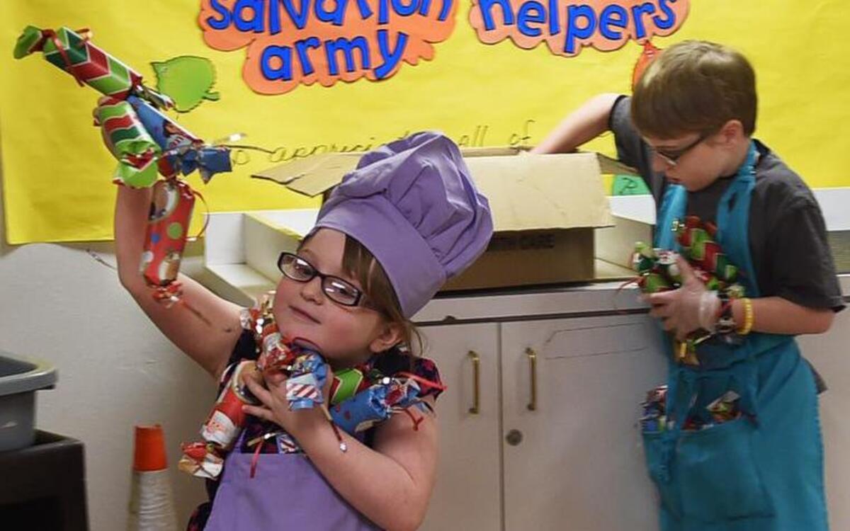 Seven year-old Stephanie Cornelius and her 12-year-old brother Nathan place small table-top gifts in preparation for the annual Christmas meal served in the downtown Olympia Salvation Army hall on Friday.