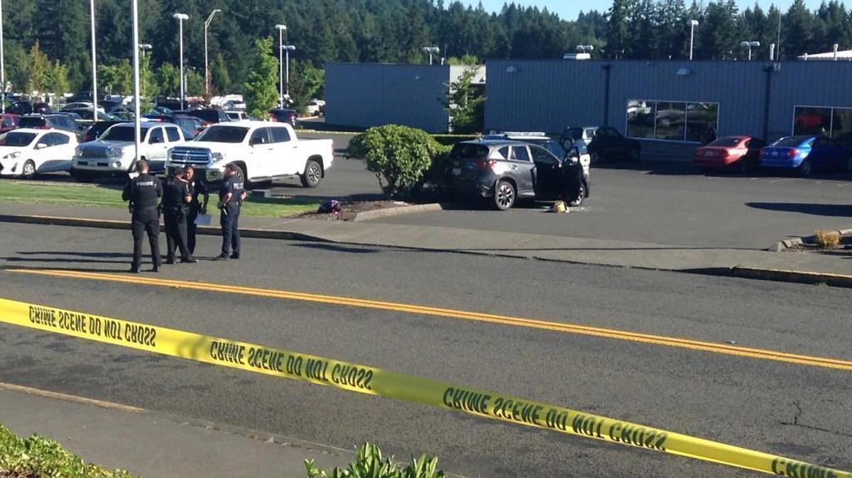 Police investigate a scene at the Olympia auto mall on Monday evening. A male suspect shot and killed two women before leading police on a car chase.