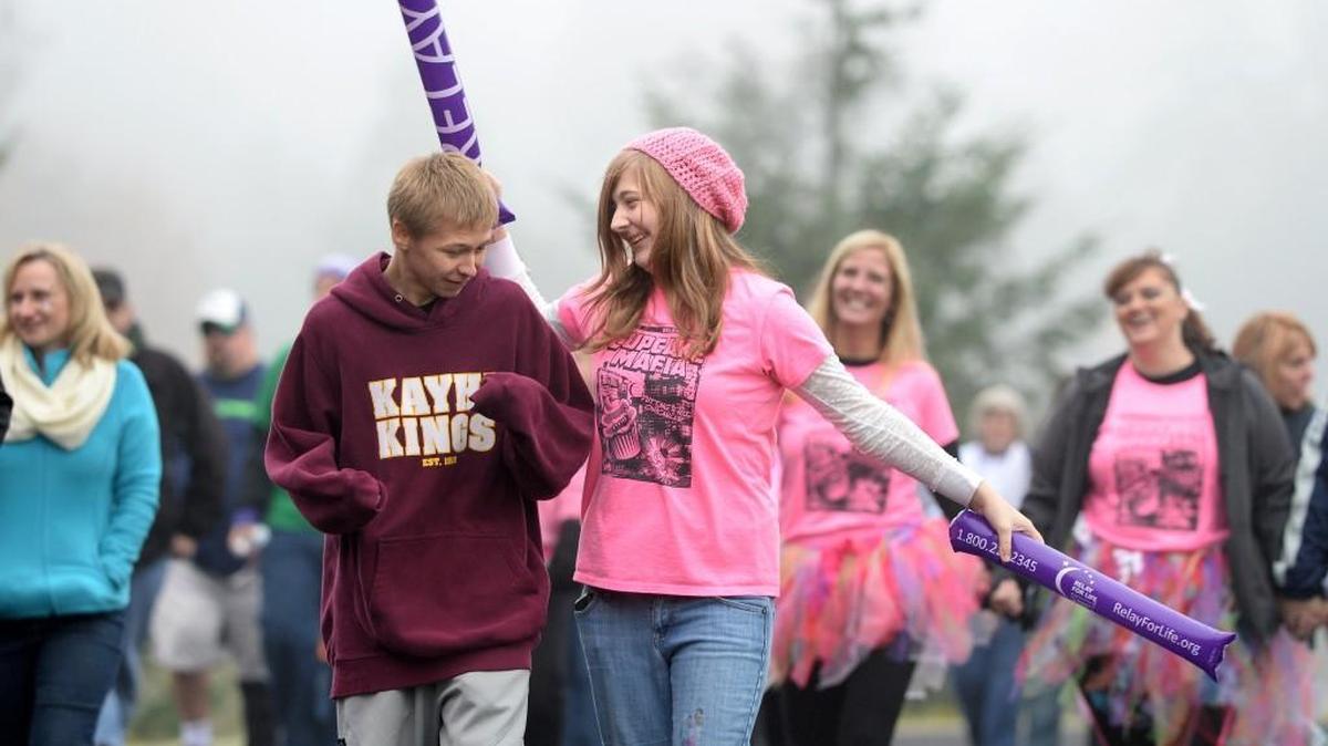 Tristan Munroe, 18, and Rachel Burkhart, 16, foreground from left, walk a lap around the track at Timberline High School during a kickoff to 2014 Relay For Life in Lacey on Oct. 19, 2013. This year’s relay is June 4-5.