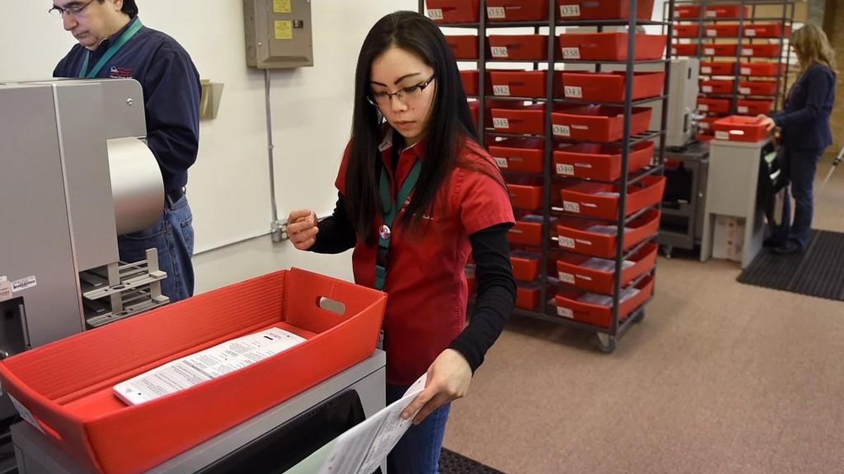 Thurston County Elections' staff Dan Zertuche and Lynne Watanabe begin processing ballots as part of the Dec. 2 recount for the Port of Olympia District 3 race between EJ Zita and Jerry Farmer.