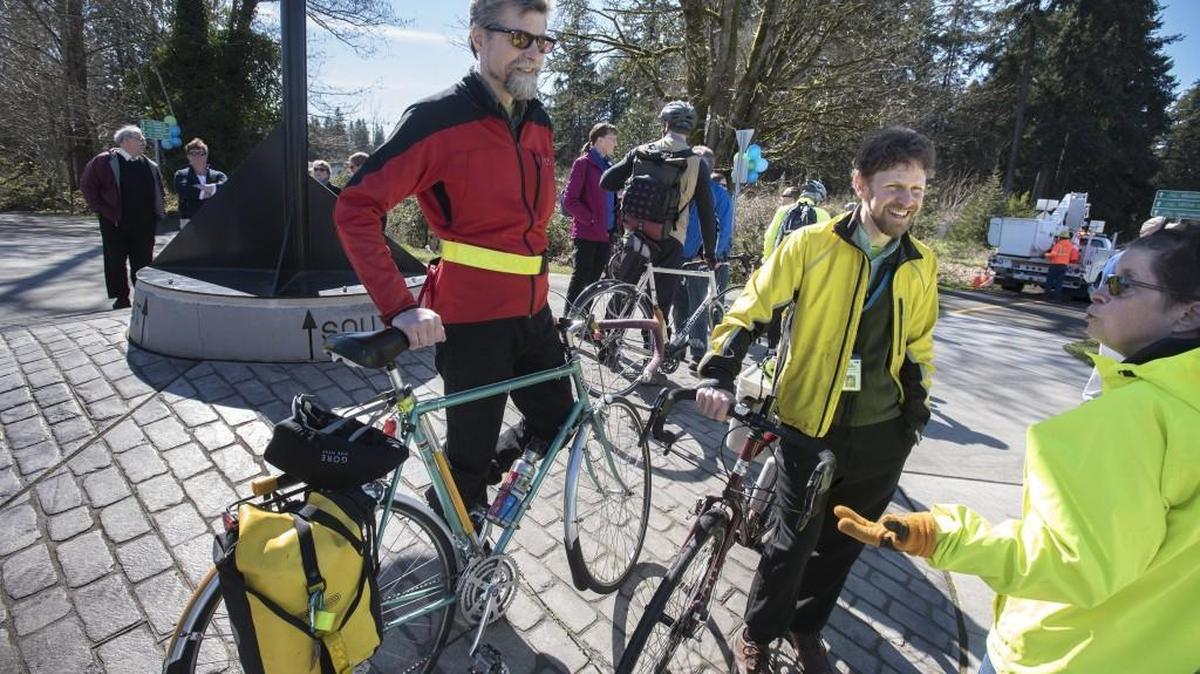 Bicycle commuting advocates Duncan Green (from left), Chris Hawkins and Lee Miller chat during the dedication of the newly redesigned intersection of the Chehalis Western and Woodland trails - featuring the state's first bicycle roundabout - on Thursday, March 17, 2016.