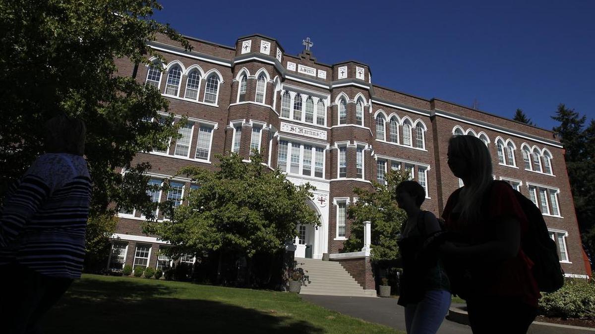 Students walk past the Old Main Building at Saint Martin’s University in Lacey.