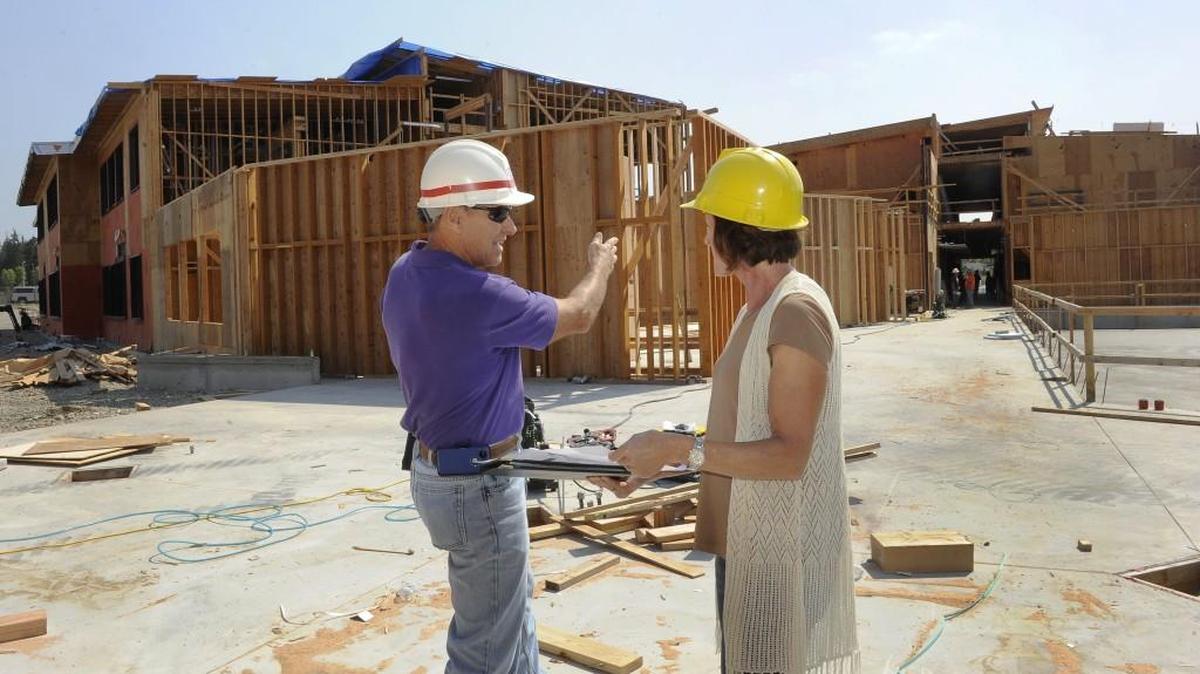 
Mike Laverty, left, a North Thurston Public Schools design and construction official, and Karen Owen, principal at Nisqually Middle School, go over floor plans during an August tour of the newly named Salish Middle School. A committee will reveal recommendations this week on which neighborhoods will be served by the school when it opens next fall, as part of a districtwide boundary review process.

