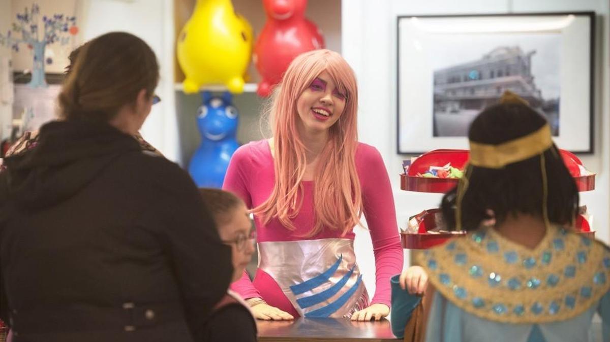 File photo: Kelsi Minerd, a sales associate at Captain Little toy store, dresses as Jem as she greets visitors to the store on Halloween in downtown Olympia on Saturday, Oct. 31, 2015.