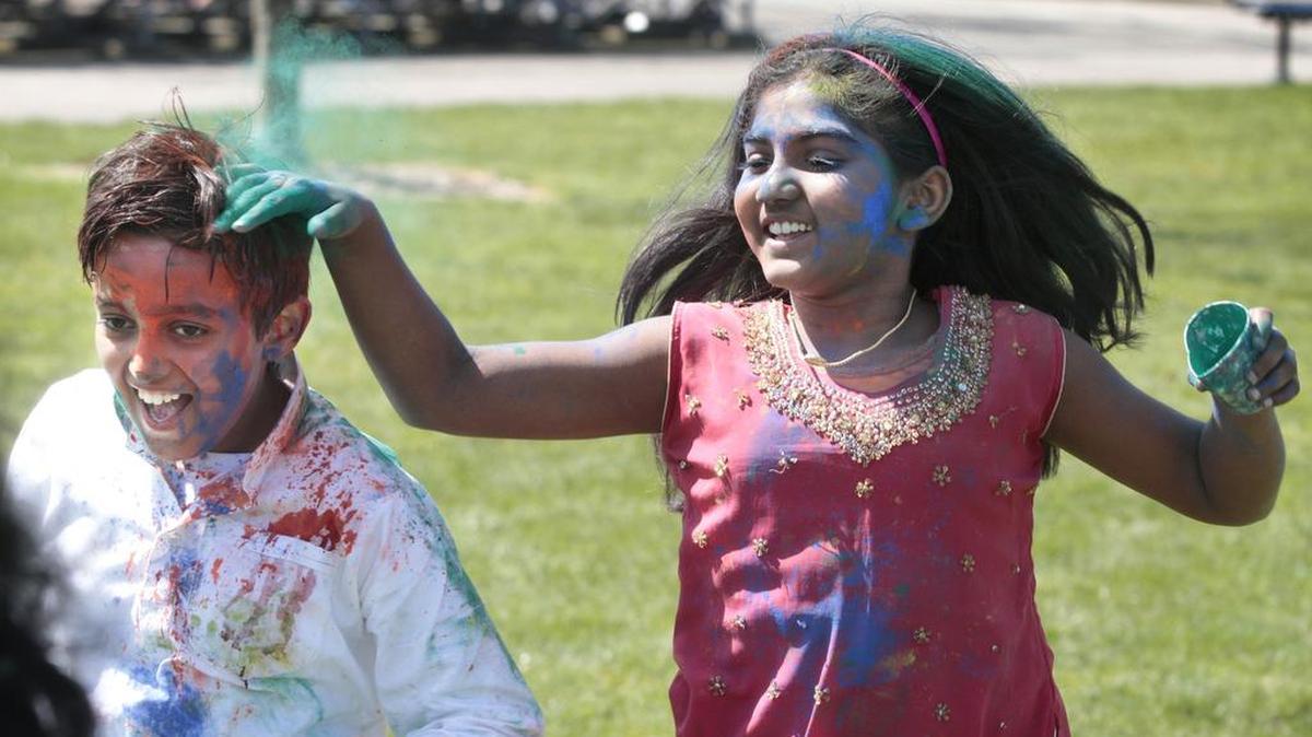 Eight-year-old Aarav Verma, left, gets a playful coating of color from Nidhi Krishnakumar, 10, during last year’s Holi festival of colors celebration at Rainier Vista Park in Lacey on April 18.