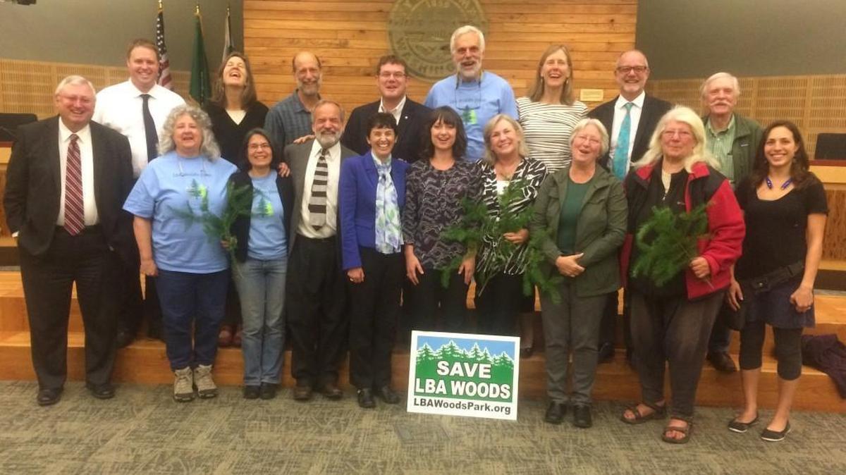 Supporters from the LBA Woods Park Coalition join Olympia City Council members and city staff for a celebratory photo Tuesday night after the council approved a purchase option for 72 acres in southeast Olympia.