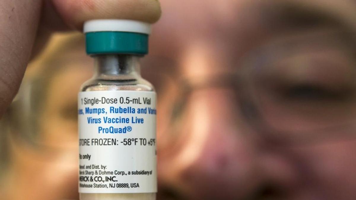 FILE, a pediatrician holds a dose of the measles-mumps-rubella (MMR) vaccine. A study published in the journal Science suggests the measles vaccine not only prevents measles, but may also help the body ward off other infections. The vaccine was in the spotlight this year after a large measles outbreak linked to Disneyland sickened people in the U.S., Mexico and Canada. (AP Photo/Damian Dovarganes, File)