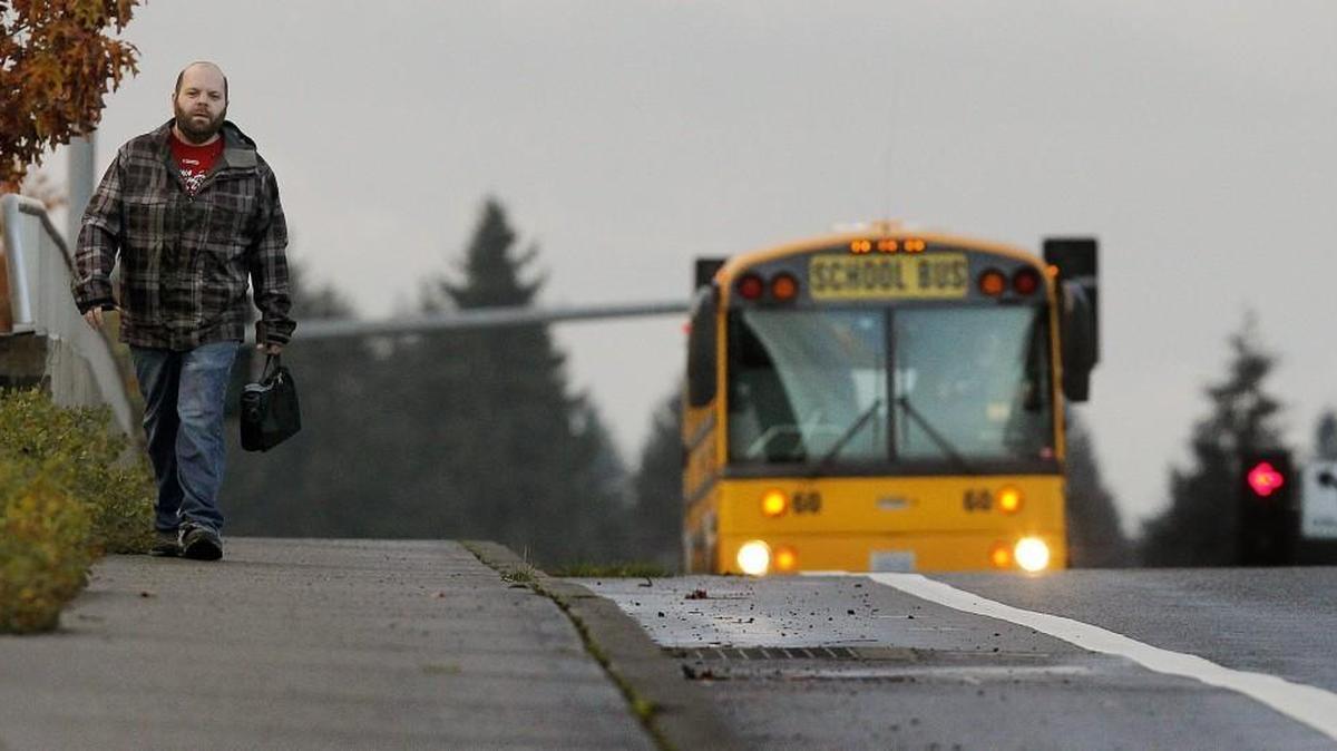 Xerox call center agent Jason Webster makes his regular 1.5-mile trek to work across the Marvin Road I-5 overpass early Wednesday morning from the bus stop near the Hawks Prairie Walmart. There is no Intercity Transit bus line to Xerox.
