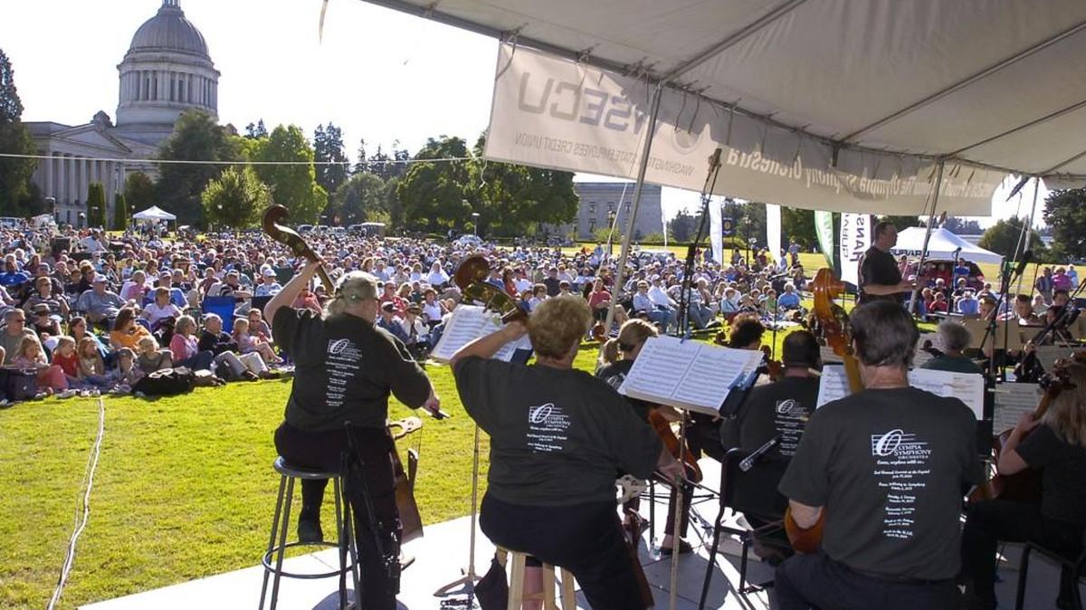 FILE PHOTO: As an audience of several thousand gather on the campus lawn, Huw Edwards directs the Olympia Symphony Orchestra as part of their "Concert at the Capitol" series. This year the annual outdoor concert has expanded into a daylong festival.