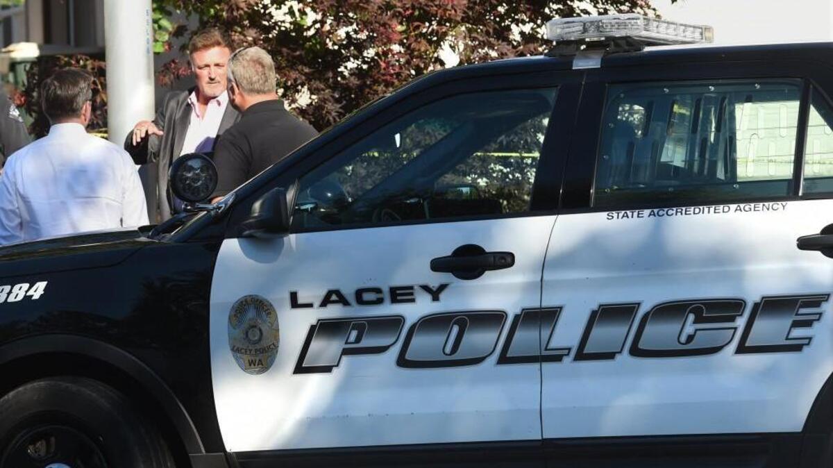 Lacey Police Commander Chris Ward talks to Thurson County Prosecutor Jon Tunheim (right) and Jeffery Lippert, chief criminal deputy prosecutor, at the scene of Monday’s shooting.