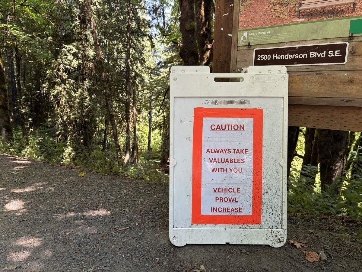 A sign is stationed at the entrance to Watershed Park, reminding visitors to remove valuable items from cars amidst a spike in recent car prowls. Olympia police say a dozen break-ins have occurred at the park in July alone.