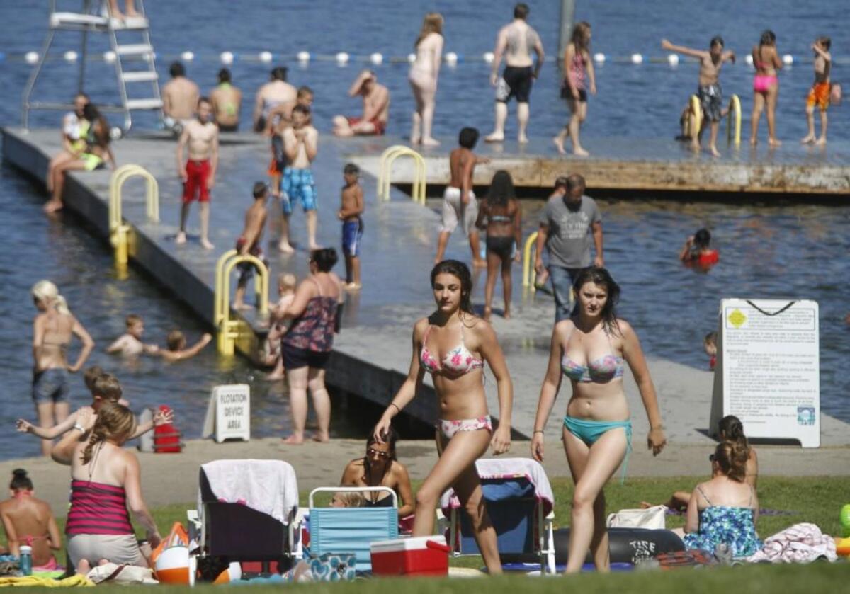Swimmers and sun bathers fill the hillside at Long Lake Park in Lacey as temperatures climbed into the 80s on Thursday, July 10, 2014.
