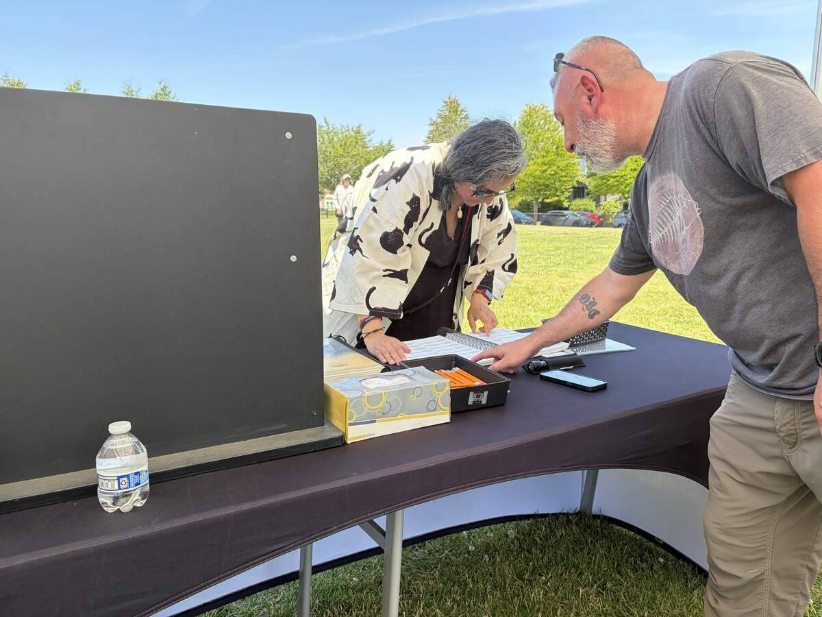 Organizer Jorge Castillon assists a visitor in locating a name on The Wall That Heals, a three-quarter scale replica of the Vietnam Veterans Memorial in Washington D.C. The wall arrived in Lacey Wednesday and is open to the public 24/7 through Sunday, June 28.