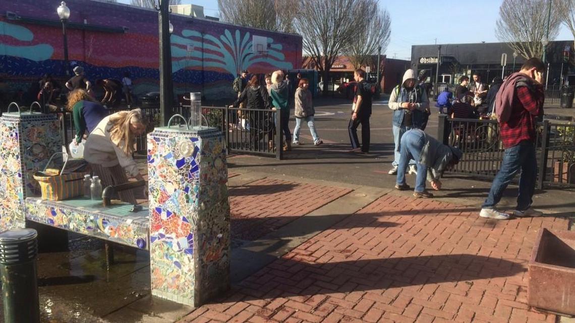 The Artesian Commons in downtown Olympia was busy on a sunny afternoon Thursday with people socializing and bottling water from the historic artesian well.