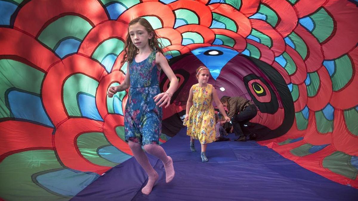 Hailey Tamerow, left, and Maddie Walsh, both 7, walk through the 40-foot-long Red Salmon inflatable tent after listening to storytelling during the 2015 Nisqually Watershed Festival at the Nisqually Wildlife Refuge. The 2018 Nisqually Watershed Festival is Saturday.