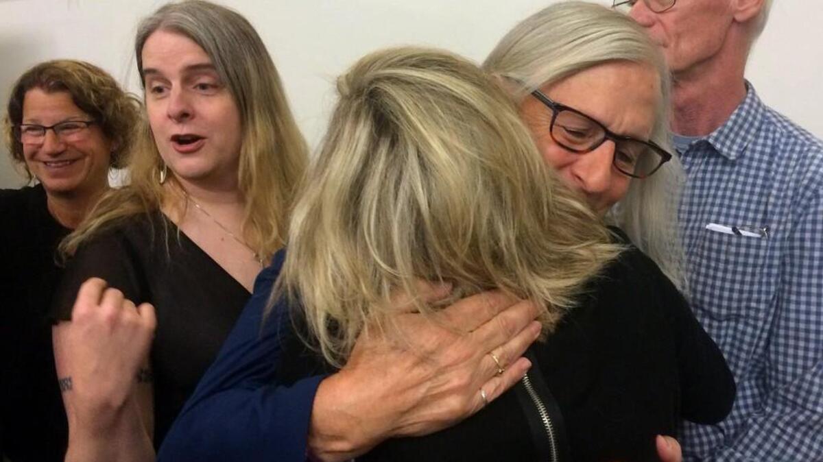 Cheryl Cristello (facing camera) receives a hug from a supporter after speaking Thursday at a Washington Won’t Discriminate press conference at the University of Washington Tacoma. Miriam Barnett, left, CEO of the Pierce County YWCA and Elayne Wylie, a director at the Gender Justice League, also spoke. At right is Cristello’s husband, Tom Jenkins.