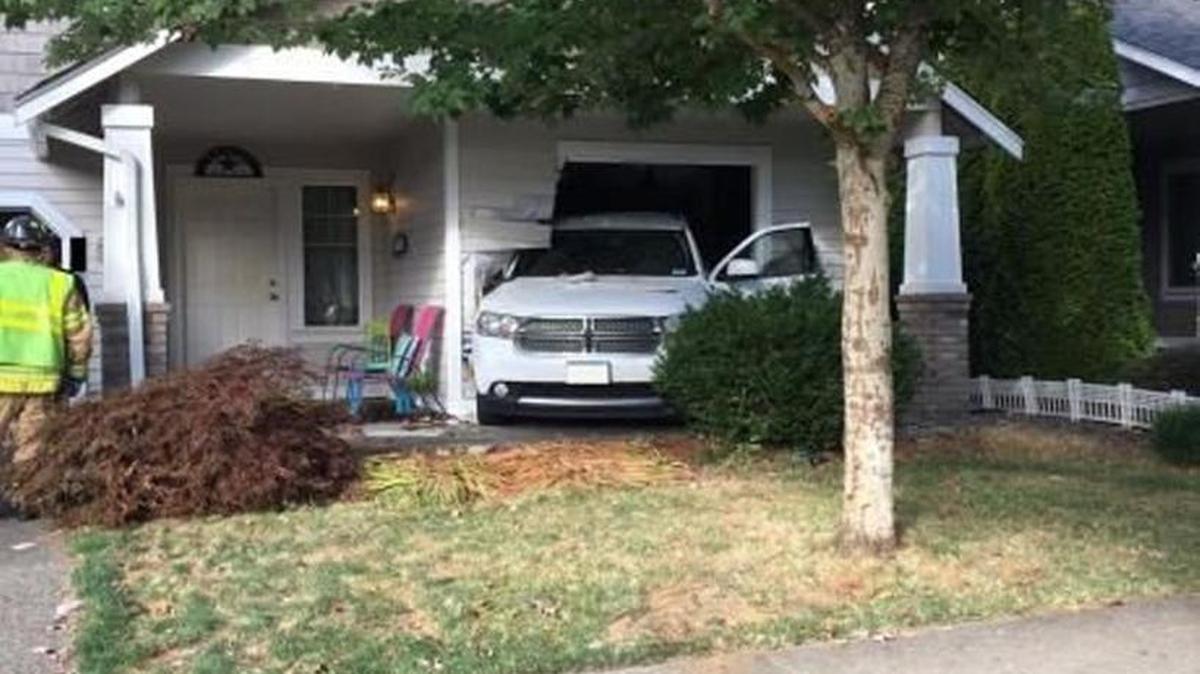 A boy was behind the wheel of an SUV Sunday morning when it backed over a 33-year-old woman, then crashed into a neighboring house. The woman was in stable condition Monday at Providence St. Peter Hospital.