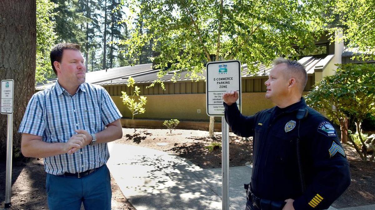 Lacey Mayor Andy Ryder and Police Sgt. Dave Campbell stand next to the two spaces for the e-commerce zone in the City Hall parking lot. The location offers a safer place to finalize online transactions.