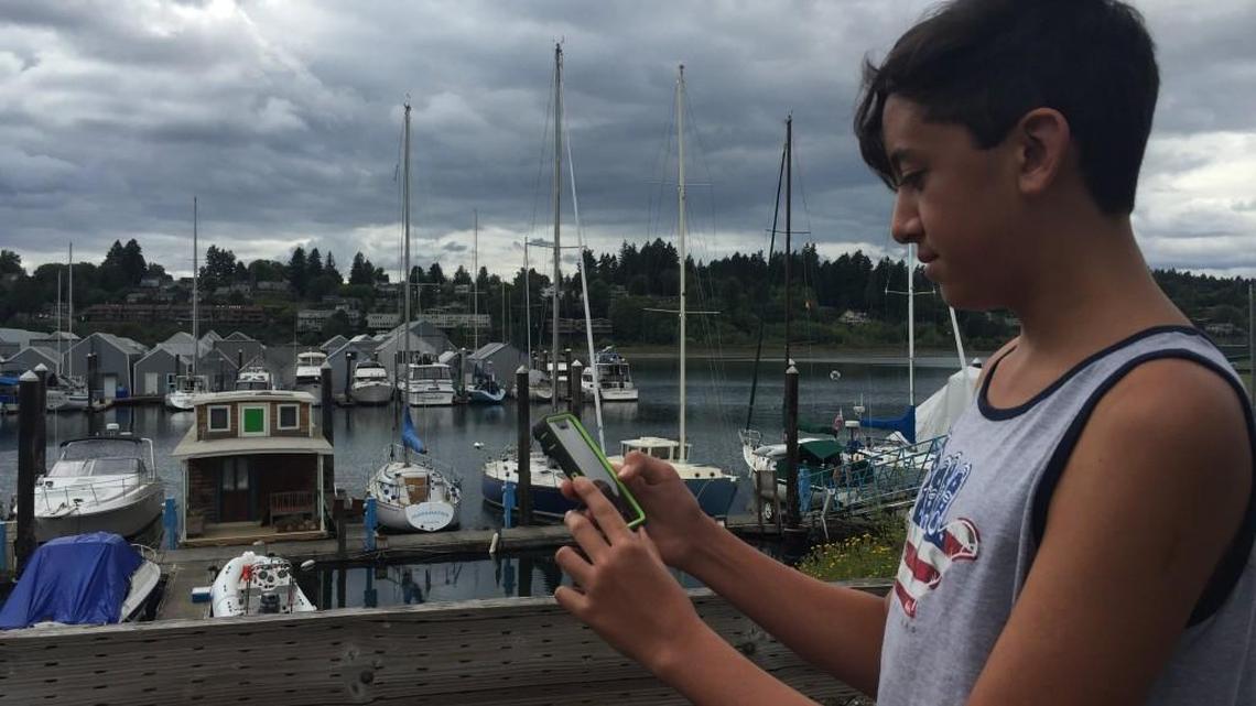 Dylan Awana of Hawaii, who was in Olympia visiting family this week, searches for Pokémon Monday on Percival Landing. He said his whole family will use the game during an upcoming road trip.