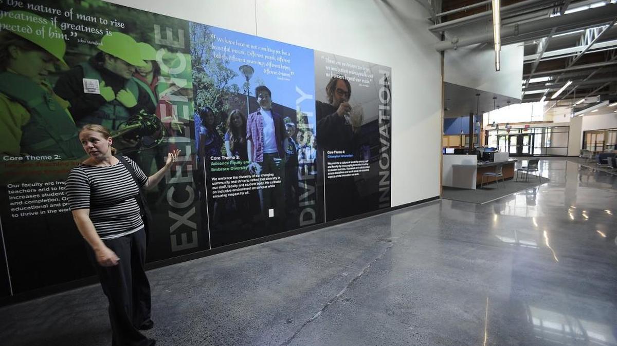 
College spokesperson Kelly Green points out the large murals in the main hall area during a tour as the South Puget Sound Community College’s new Lacey campus readies to open Monday.
