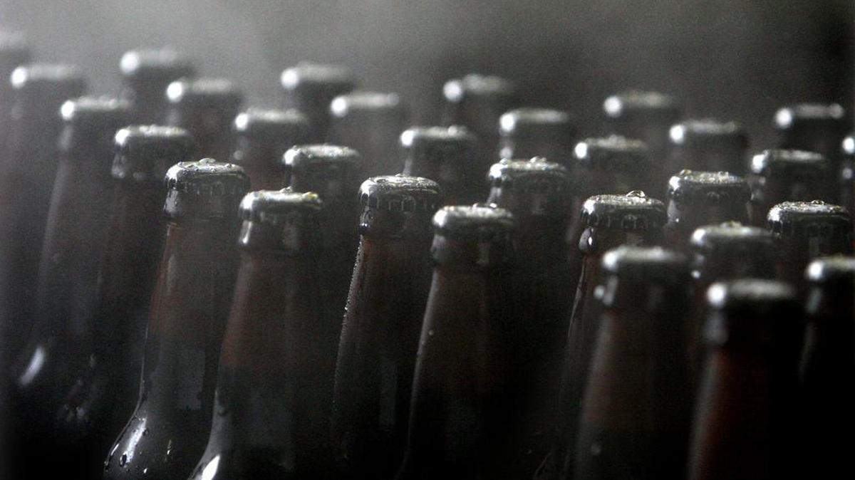 FILE PHOTO: Freshly capped bottles emerge from the steam during a bottling run at the Fish Brewing Company.