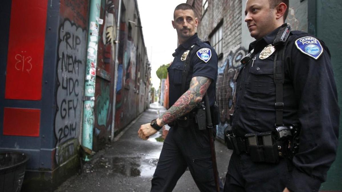 File photo: Olympia police officers Javier Sola Del Vigo (left) and Paul Frailey keep an eye on activities during their nightly walking patrol of downtown Olympia in 2015.