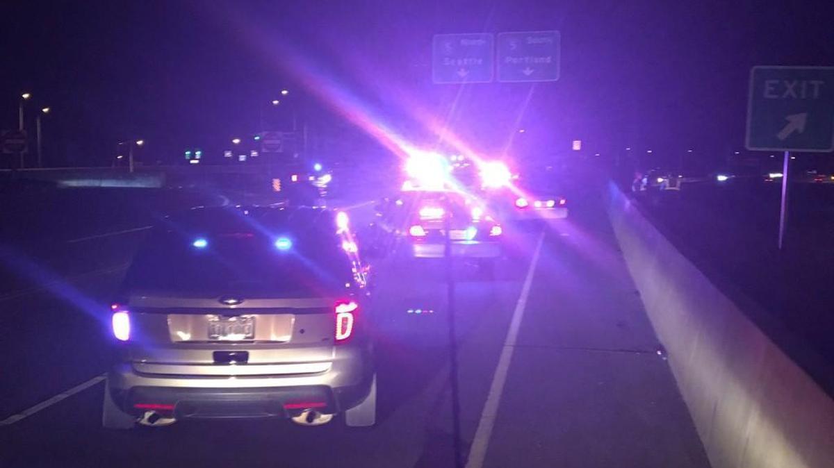 Police investigate the scene after a woman was found dead near state Route 16 on Tuesday in Tacoma.