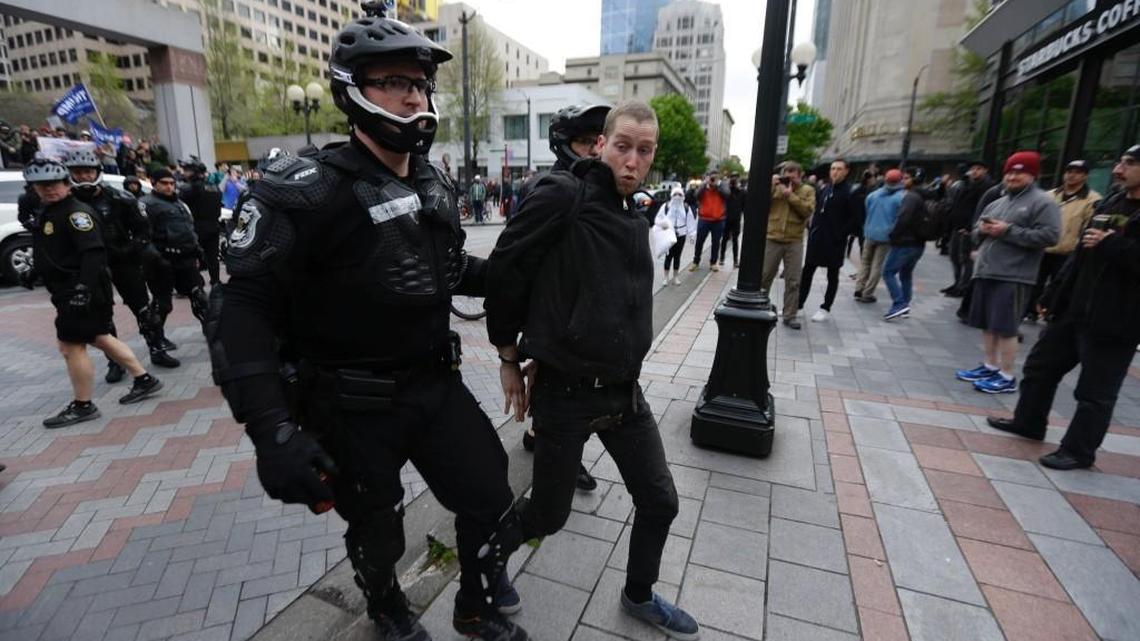 Seattle police arrest a man who allegedly threw a rock at supporters of President Donald Trump during May Day protests there Monday afternoon. The man is a 26-year-old Olympia resident, police said.