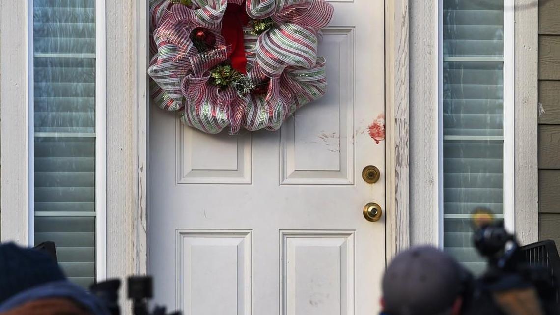 Blood is visible on the door as television news crews take video of the home Monday at 8406 49th Loop SE where a man was shot and killed by a member of the Thurston County SWAT team around 8:30 p.m. Sunday. Official reports state that he was shot as he held a knife to the throat of his 3-year-old daughter after apparently stabbing his cousin at the residence.
