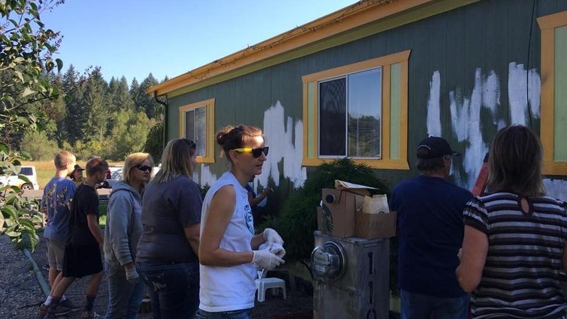 Volunteers clean racist graffiti off a Tenino home.