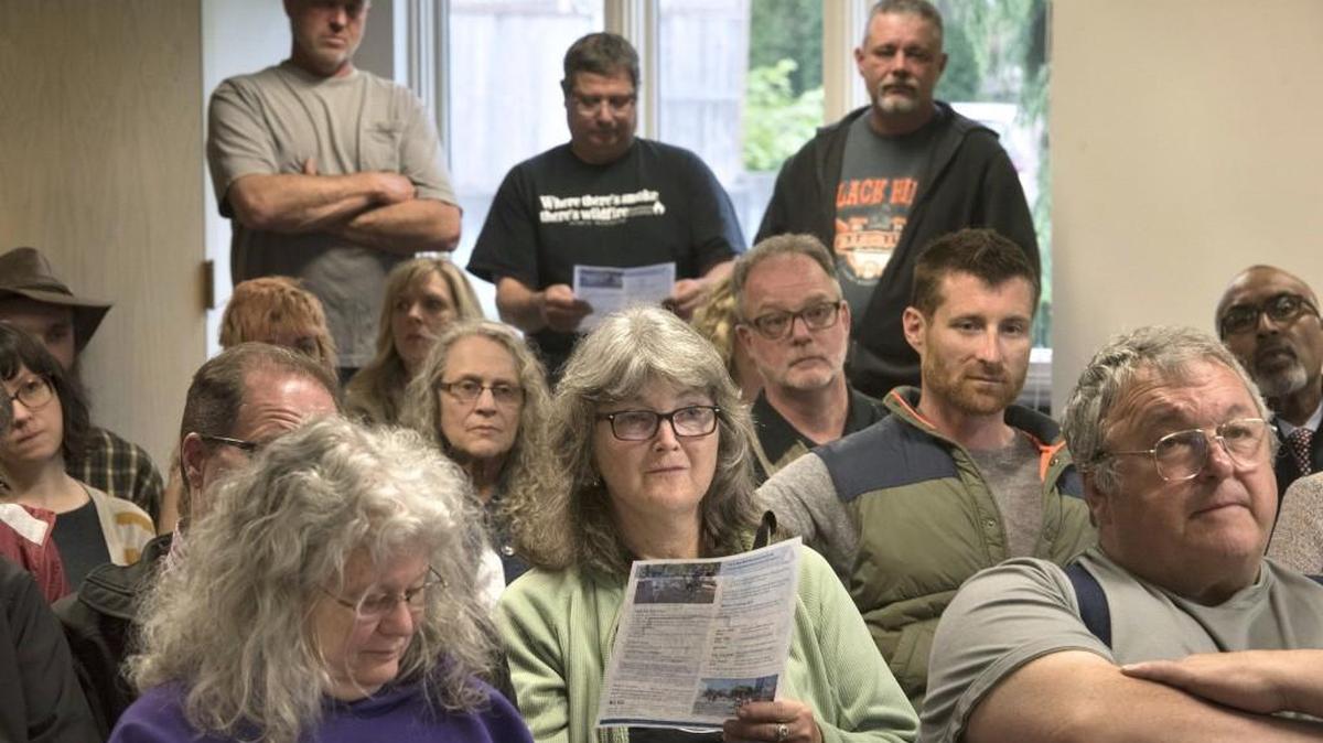 Julie Bennett (center) and fellow Eastside neighborhood residents listen to a presenter during a meeting with Olympia police at United Methodist Church in Olympia on Wednesday.