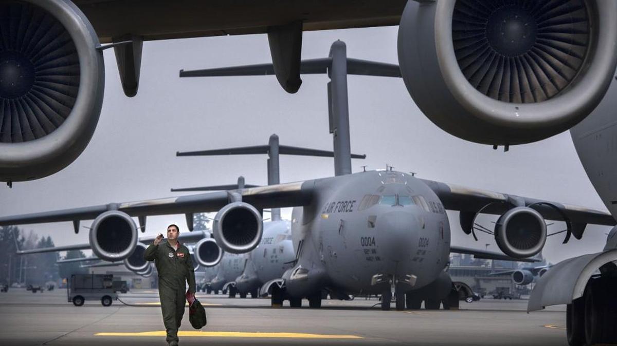 Lt. Colonel Nathan Campbell, Commander of the 10th Airlift Squadron, checks over a C-17 with his flashlight at the airfield of JBLM on Thursday, Jan. 8, 2015. The Air Force will inactivate the 10th Airlift Squadron.