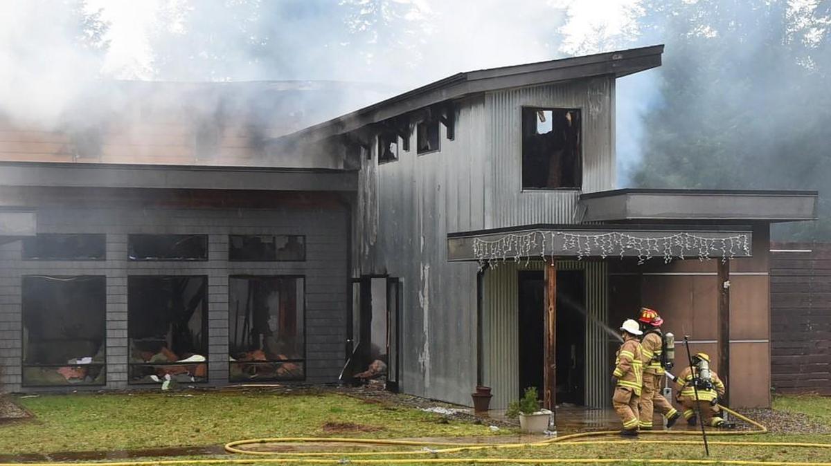 From left, Assistant Chief Brent McBride, Lt. Adam Graham and firefighter Jake Zvirzdys from the South Bay Fire Dept. watch for hot spots Tuesday after an early morning fire destroyed a home in the 6900 block of Marvin Road NE in what is believed to have been arson.