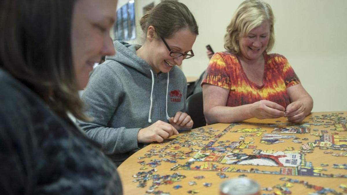 Sonja Mundt, center, and Kathy Thompson of Olympia, who were unexpectedly delayed by a landslide on Interstate 5, work on a puzzle at Woodland High School Thursday, while waiting for the freeway to reopen. The Red Cross provided many stranded travelers with food and shelter at the school.