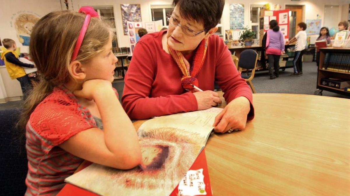 Toni Miklich reads with Madison Elementary School second-grader Mary Fish in 2013. You can join the United Way's Reading Buddy program by attending orientation from 1:30-3 p.m. Wednesday at First United Methodist Church in Olympia.
