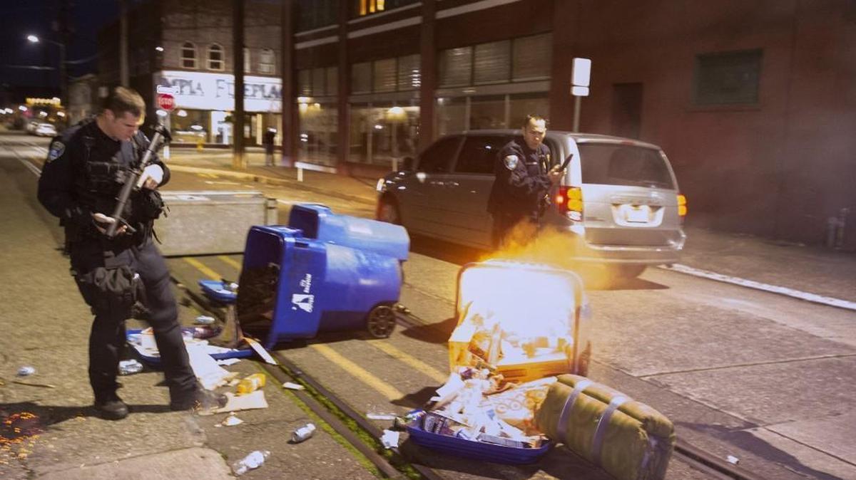 Olympia police respond to a garbage fire set by protesters on Jefferson Street in downtown Olympia early on Friday, Nov. 18, 2016.