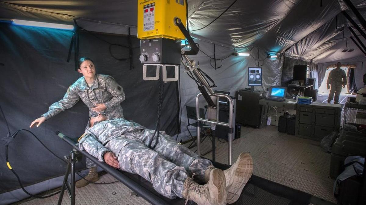 Washington National Guard X-ray technicians Spec. Holly Bench, top, and Spec. Jorie Fernandez demonstrate how a mobile X-ray machine works in a field hospital during Cascadia Rising drill at the Mason County Fairgrounds on Thursday.